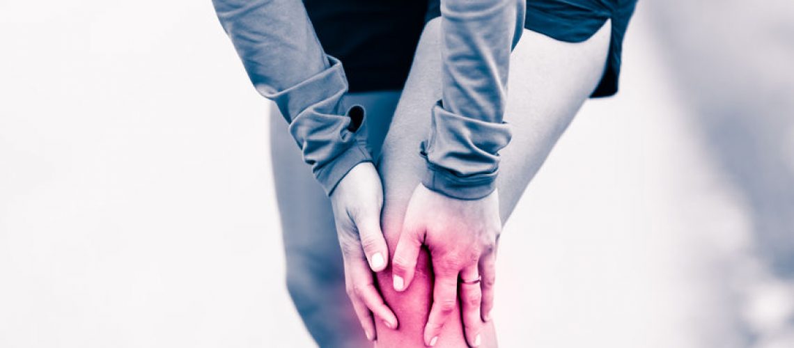 47866085 - runners knee leg pain, woman holding sore and overtrained painful knee, sprain or cramp ache filled with red pink bright place. overtraining injured person when exercising or running outdoors.